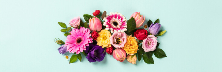 Creative layout made with beautiful flowers on blue background. Flat lay. Spring minimal concept