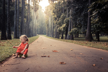 Lonely carefree child girl playing on road in park alone concept loneliness carefree childhood...