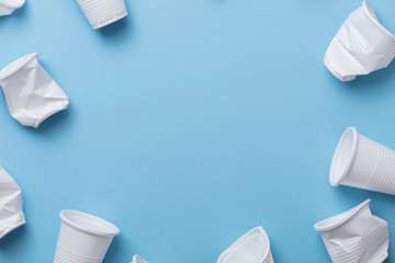 Single use white plastic cups on a blue background