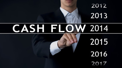 Cash flow for 2014, businessman selects financial report on virtual screen