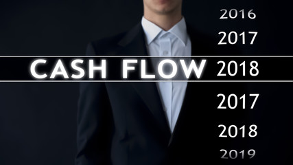 Cash flow for 2018, businessman selects financial report on virtual screen