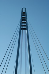 Cables and tower of the suspension bridge with blue skies in the background