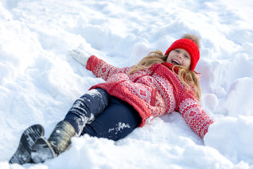 Portrait of a happy child in the winter. Cheerful girl outdoors