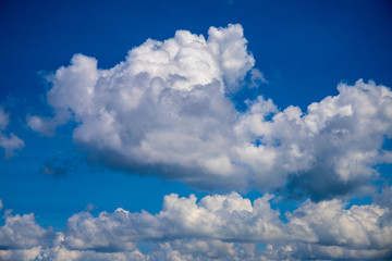 Naklejka na ściany i meble White cloud on blue sky. Sunny cloudscape photo background. Optimistic skyscape with fluffy cloud.