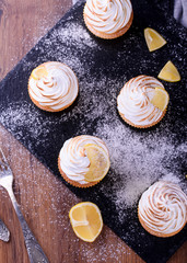 Lemon muffins with protein cream on a slate board with powdered sugar and honey