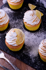 Lemon muffins with protein cream on a slate board with powdered sugar and honey