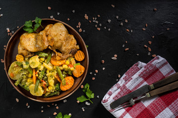 Fried chicken fillet with vegetables.