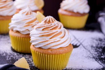 Lemon muffins with protein cream on a slate board with powdered sugar and honey