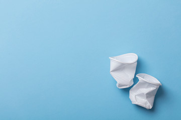 Single use white plastic cups on a blue background