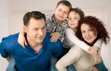 Fototapeta premium Beautiful smiling family sitting at sofa at home
