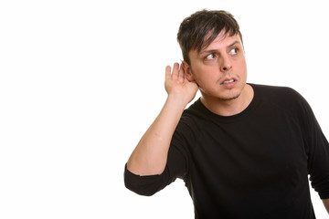 Studio shot of Caucasian man listening isolated against white background