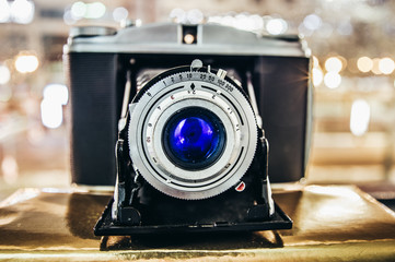 Old retro camera with blue lens and bellows