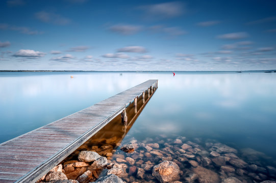 View of wooden pier in Lac d'Hourtin Carcans against cloudy sky