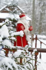 Santa Claus and Snow Maiden go out onto the terrace of their manor in the winter against the background of snow-covered fir trees.