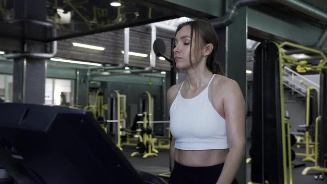 Beautiful Young Woman Athlete Walks On A Treadmill Ending An Exercise Session