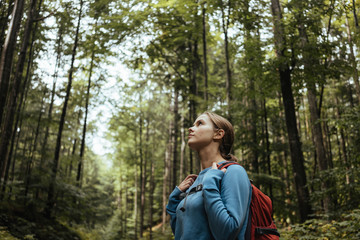 Female hiker looking at view while standing in forest