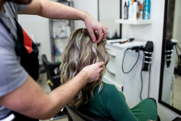 Beautiful hairstyle of mature woman after dying hair and making highlights in hair salon.