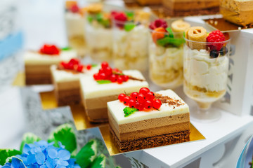 close-up of cupcakes decorated with berries and ice cream in transparent glasses