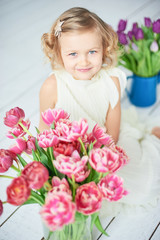 girl holding narcissus in hands. Adorable smiling little girl holding flowers for her mom on mother's day.