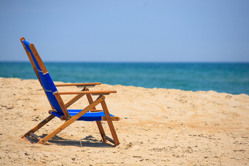 Fototapeta na wymiar Beach Chair on a Sunny Sandy Coast