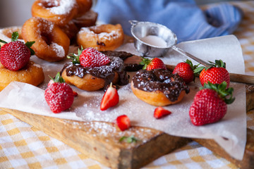 Homemade donuts with powdered sugar and strawberry 