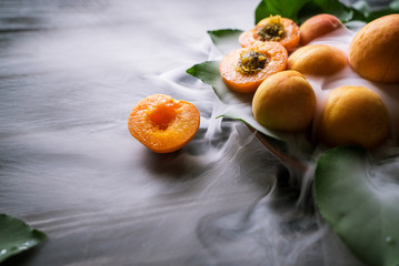 apricots and smoke on a black wooden table
