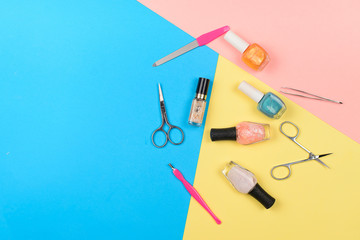  Nail polishes and tools for manicure on a colorful background