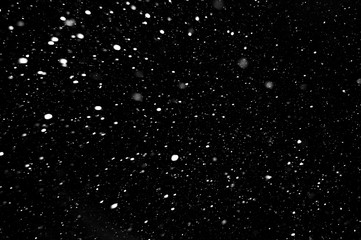 Fototapeta na wymiar snow on a black background, falling snow at night, texture with white spots on a black background