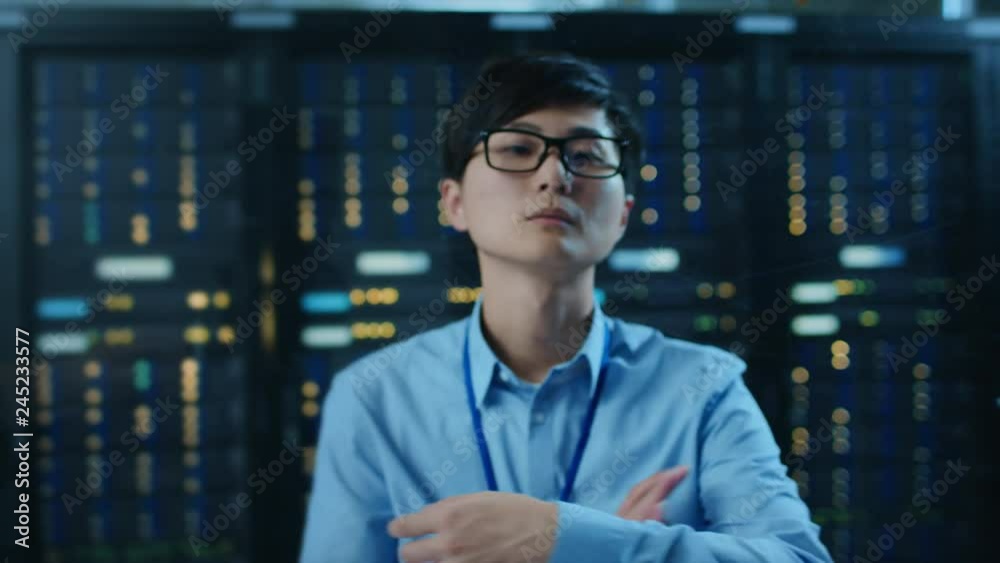 Fototapete In the Modern Data Center: Portrait of Asian IT Engineer Working With Touch Screen Device, Doing Swiping and Touching Gestures. In the Background Working Server Racks with Blinking LED Lights.