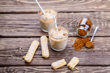  Iced coffee with ice and milk on a wooden table.