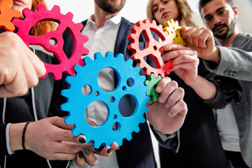Business team connect pieces of gears. Teamwork, partnership and integration concept