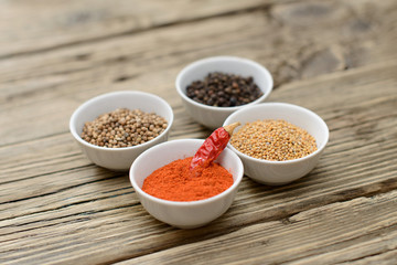  A set of spices on a wooden table.