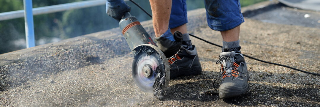 Dachdecker Bauarbeiter schneidet bei der Arbeit. Baustelle mit Dach Arbeiter "Alex" beim Flexen zum Abriß. Panorama 1:4 roofer demolition