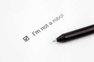 I'm not a robot - checkbox with a check mark on white paper with pen. Checklist concept