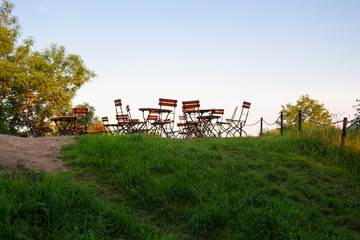 Garden furniture chairs and tables are located on a grassy hill for outdoor recreation in Finland in the summer.