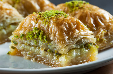 Traditional turkish dessert antep baklava with pistachio on white plate. Desserts concept