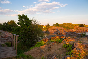 Obraz premium The rocky shore and bay of Suomenlinna Island in the Gulf of Finland is a beautiful traditional landscape of Finland, a summer evening in Finland.