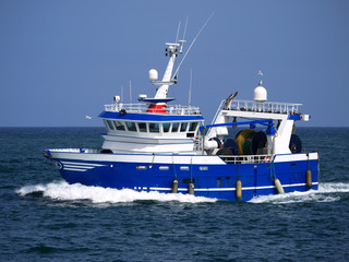 Modern trawler underway at sea to fishing grounds.