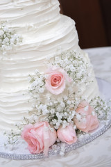 Beautiful wedding cake with bride and groom cake topper and floral decoration
