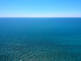 Seascape with sea horizon and clear deep blue sky. Horizontal vivid minimal landscape abstraction background backdrop. Get lost in a peaceful and misty ocean aerial view.