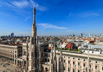 Top view from the roof of Duomo di Milano Cathedral with marble statues to the city and Galleria Vittorio Emanuele II on Piazza del Duomo square. Milan, Italy.