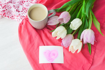 Bouquet of tulips with a mug of coffee and a gift in a red box on a pink cloth. International Women's Day, Valentine's Day, Mother's Day. Selective focus.