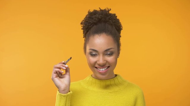 Smiling Afro-American lady putting eye shadows, visage master class, beauty