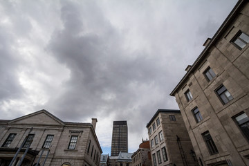 Panorama of the stone buildings of Old Montreal with a modern skyscraper taken from a nearby street.  Old Montreal, or Vieux Montreal, is the historic center of the main city of Quebec