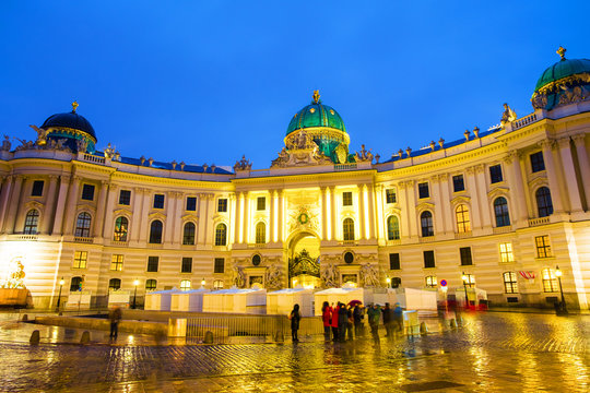 Illuminated Hofburg Palace seen from Michaelerplatz at night in Vienna, Austria