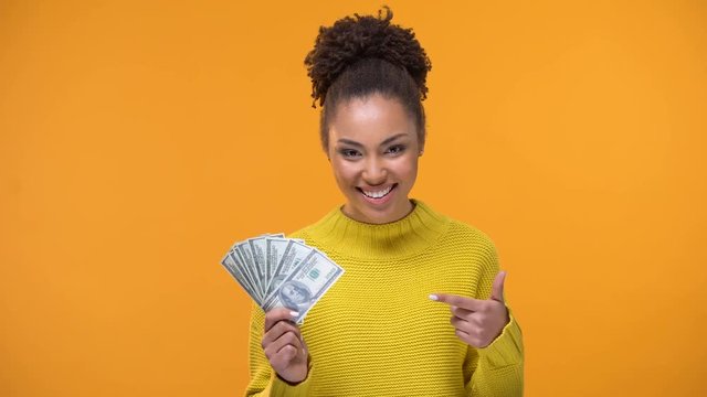 Happy African-American lady showing bunch of dollars to camera, high-paid job