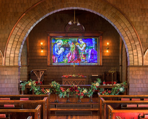 Fototapeta na wymiar Stained glass window behind the altar of the historic Faith Chapel on Jekyll Island, Georgia