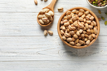 Flat lay composition with organic pistachio nuts and space for text on wooden background