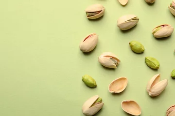 Tuinposter Organic pistachio nuts on color background, flat lay. Space for text © New Africa