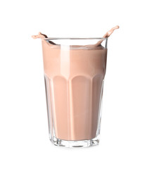 Glass with splashing chocolate milk on white background. Dairy drink